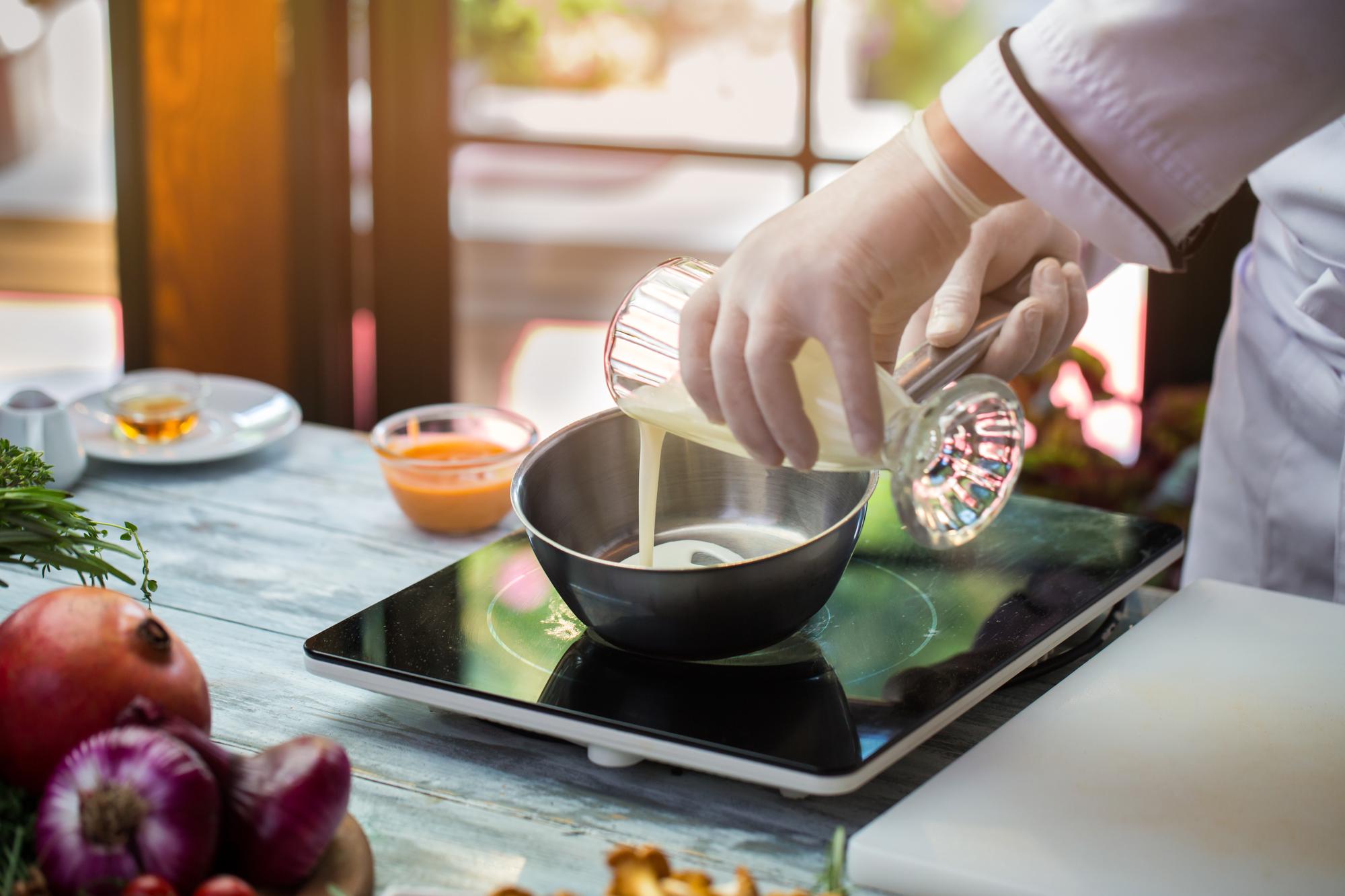 Instructor preparing a seasonal dish in studio kitchen
